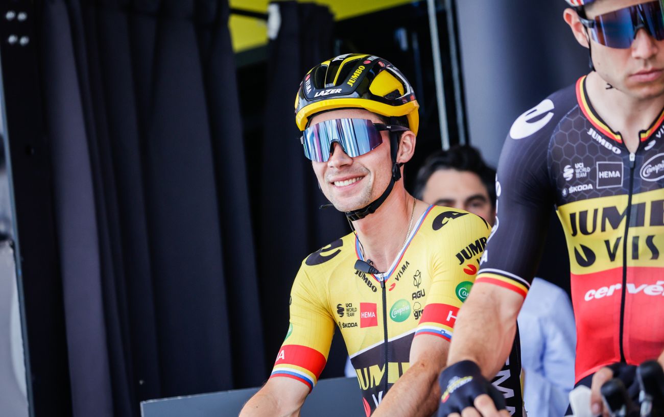 Primož Roglič smiling before a stage at the 2022 Tour de France in his Jumbo-Visma jersey.