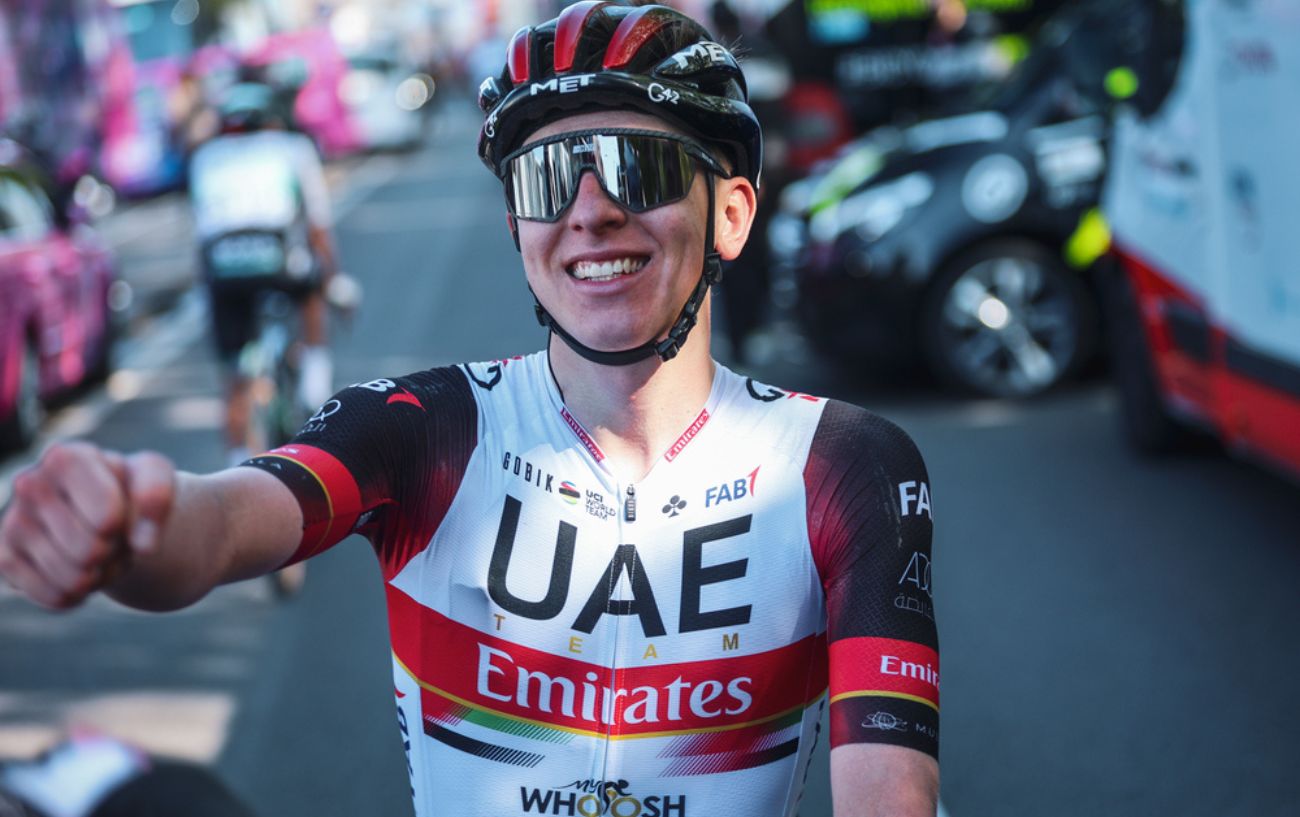 Tadej Pogačar smiling to the camera in his UAE Team Emirates jersey.