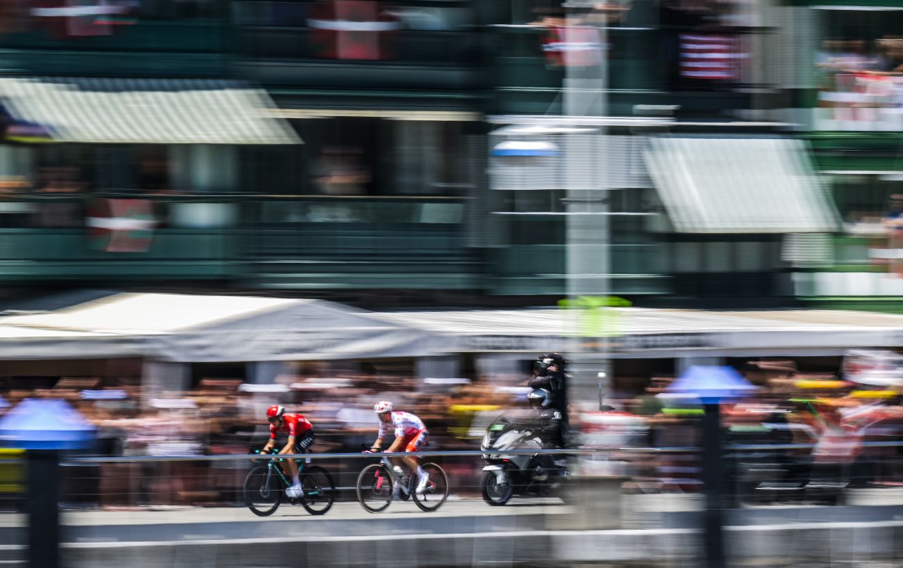 Two riders race down a high street on Tour de France 2023 Stage 3.