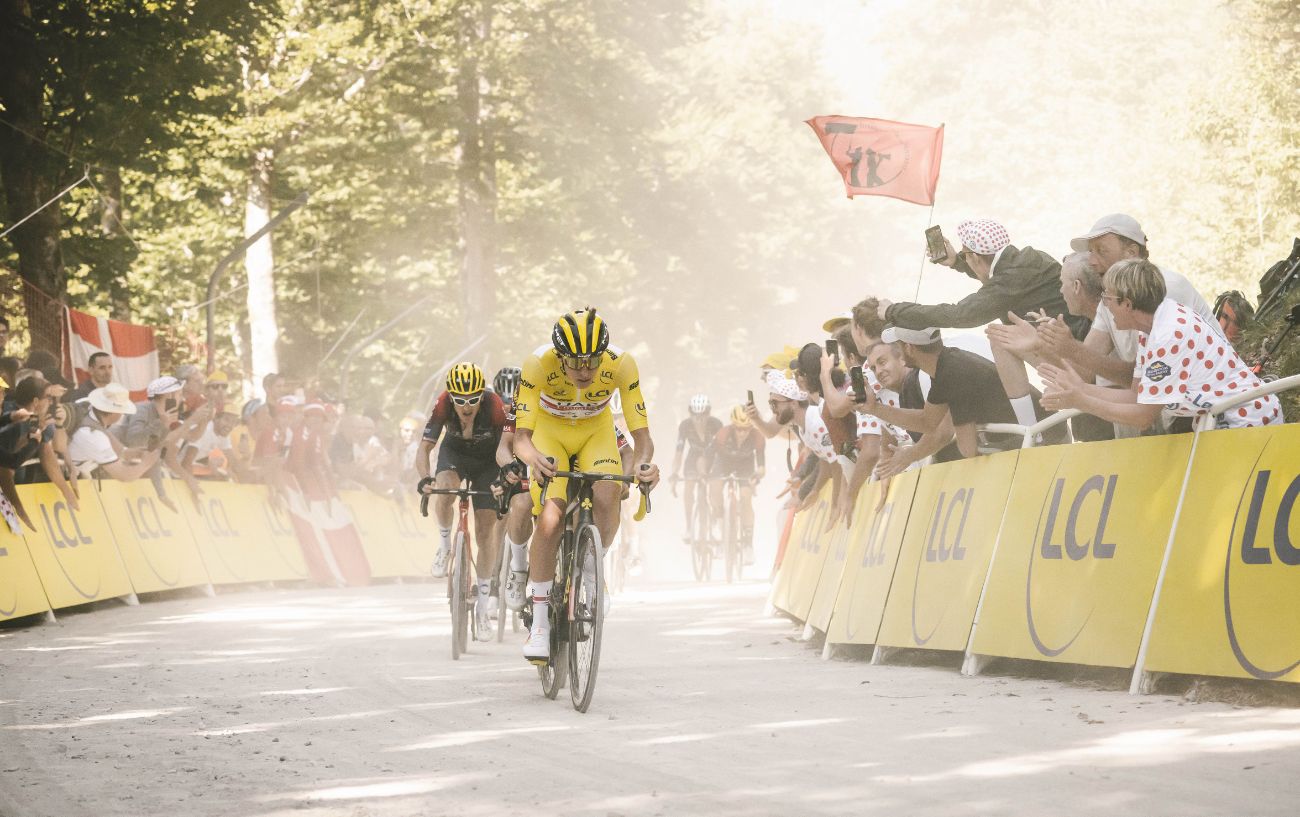 Tadej Pogacar leads the Tour de France up a gravel climb.