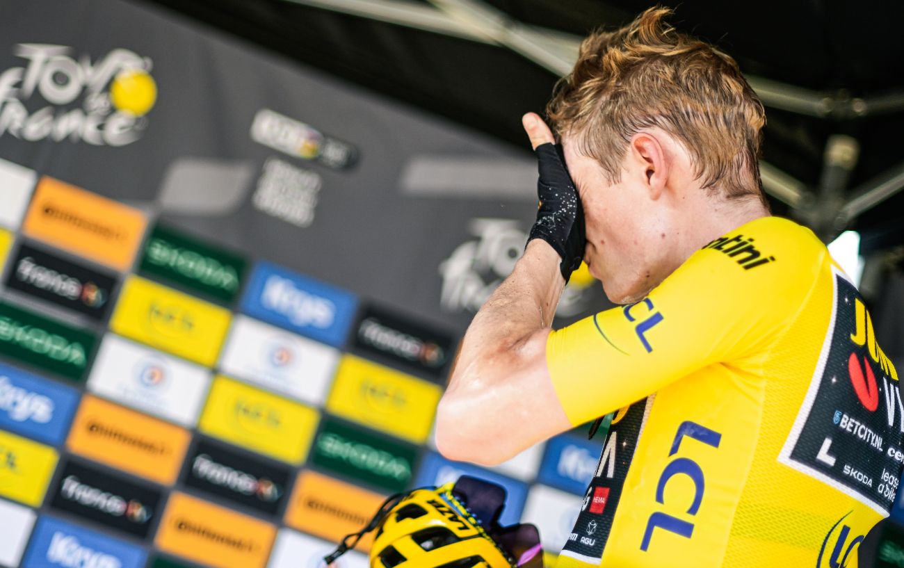 Jonas Vingegaard wipes his face at the end of an exhausting Tour de France day.