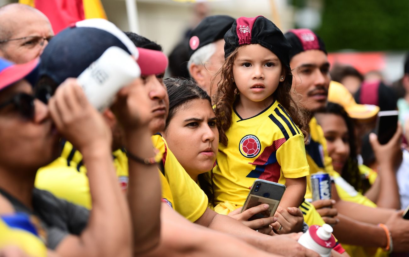 A Colombian mother and daughter wait at the side of the Tour de France.