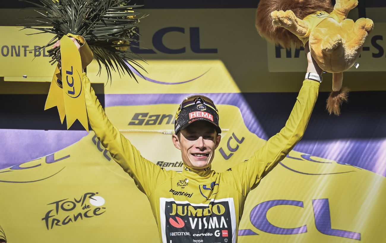 Jonas Vingegaard wears the yellow jersey on the podium at the Tour de France.