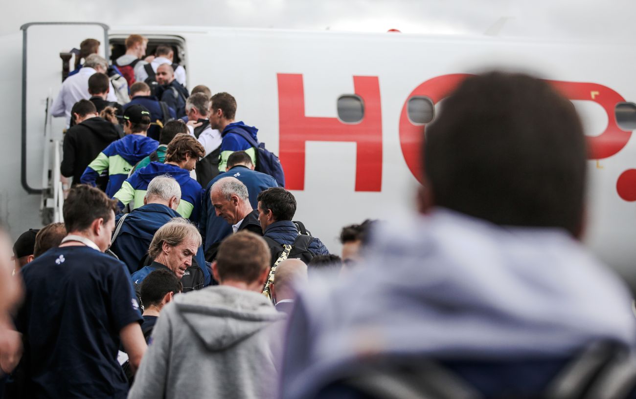 A Tour de France team boards a plane.