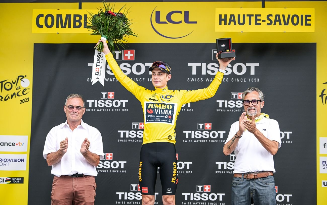Jonas Vingegaard wears the yellow jersey on the Tour de France podium.
