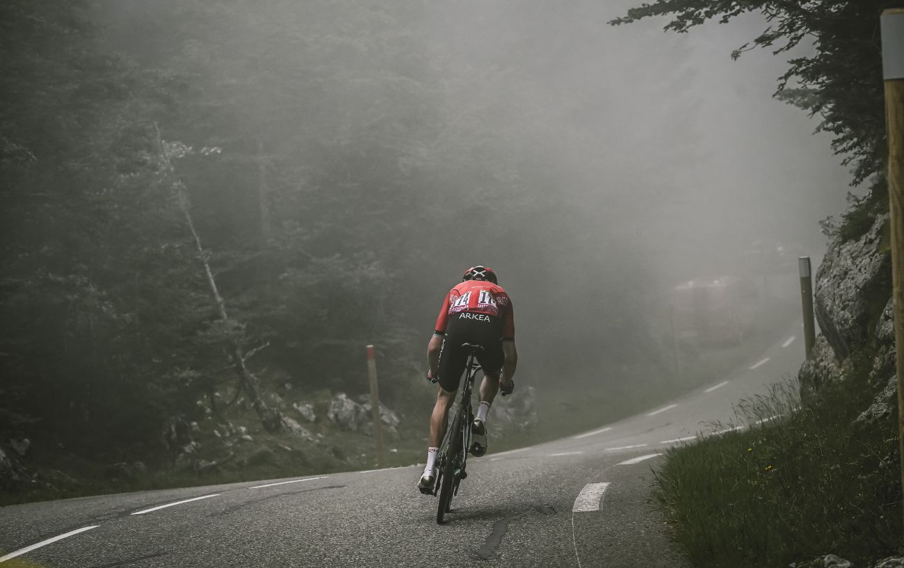 A rider descends at speed into fog at the Tour de France. Such speeds have raised questions over the safety of Tour de France average speeds.