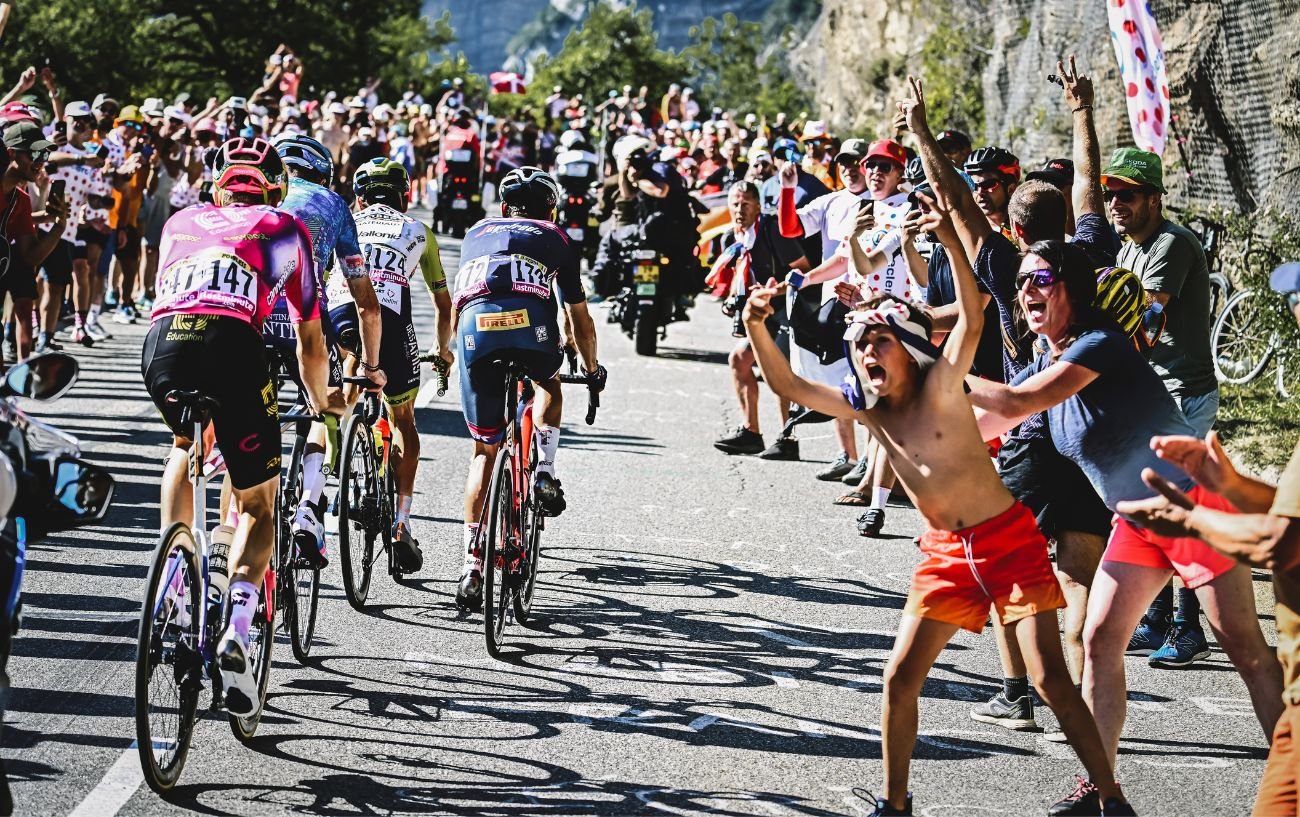 A young cycling fan roars the Tour de France past.