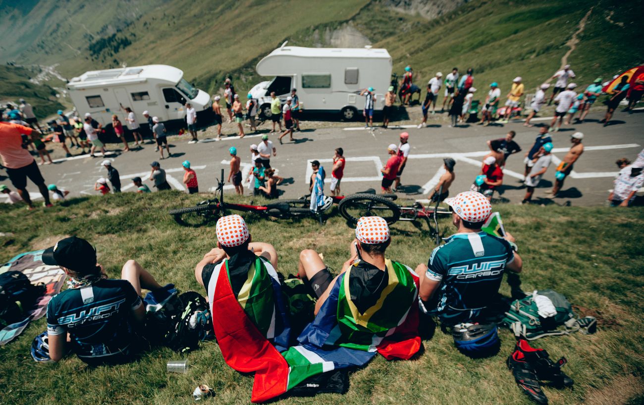 Tour de France superfans wait besides the road with their caravans in the background.