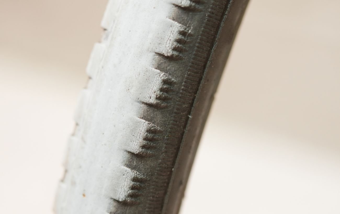 A worn out mountain bike tyre with cracks in it. 