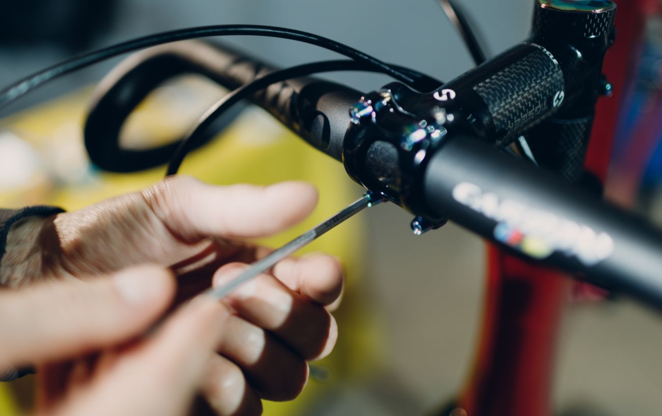 A bike mechanic uses an Allen key to adjust road bike handlebars. 