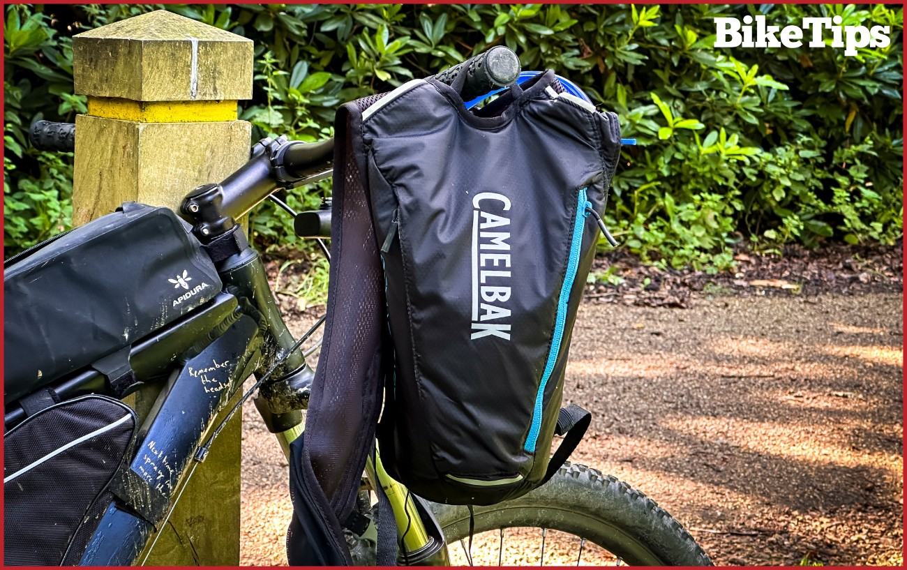 A Camelbak on the handlebars of a mountain bike.