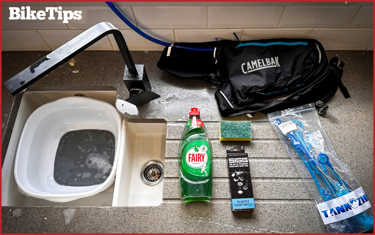 All the kit required for cleaning a Camelbak. Dishwashing liquid, sponge, bladder tablets, sink, bladder cleaning kit, and the bladder itself.