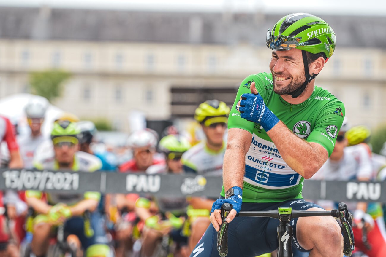 Mark Cavendish in the green jersey at the Tour de France 2021, smiling and giving a thumbs up away from the camera.