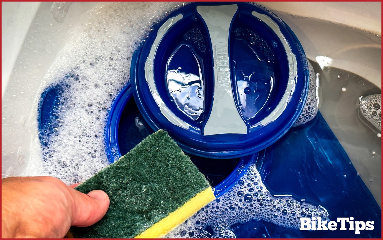 A Camelbak bladder being washed with a sponge.