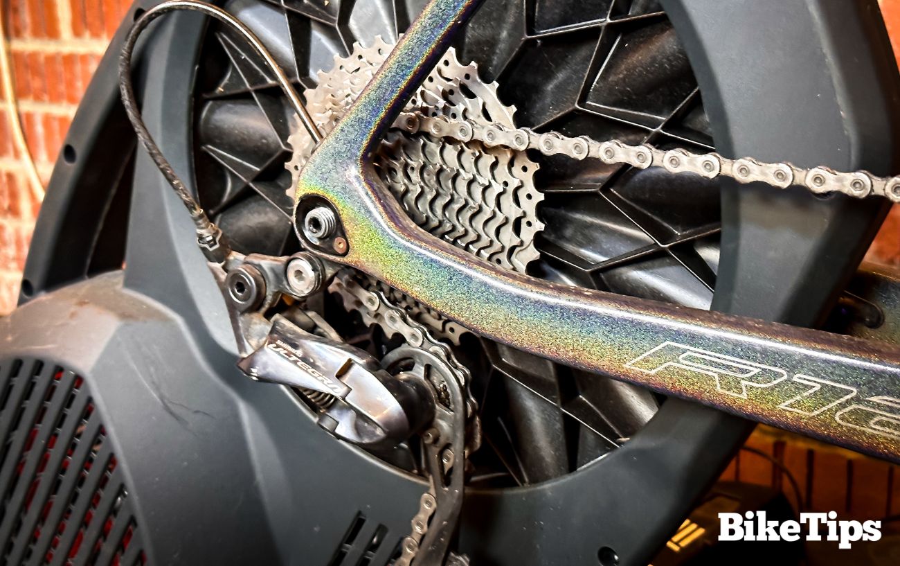 A road bike's back wheel sits in a turbo trainer, which can calculate Watts for cyclists.