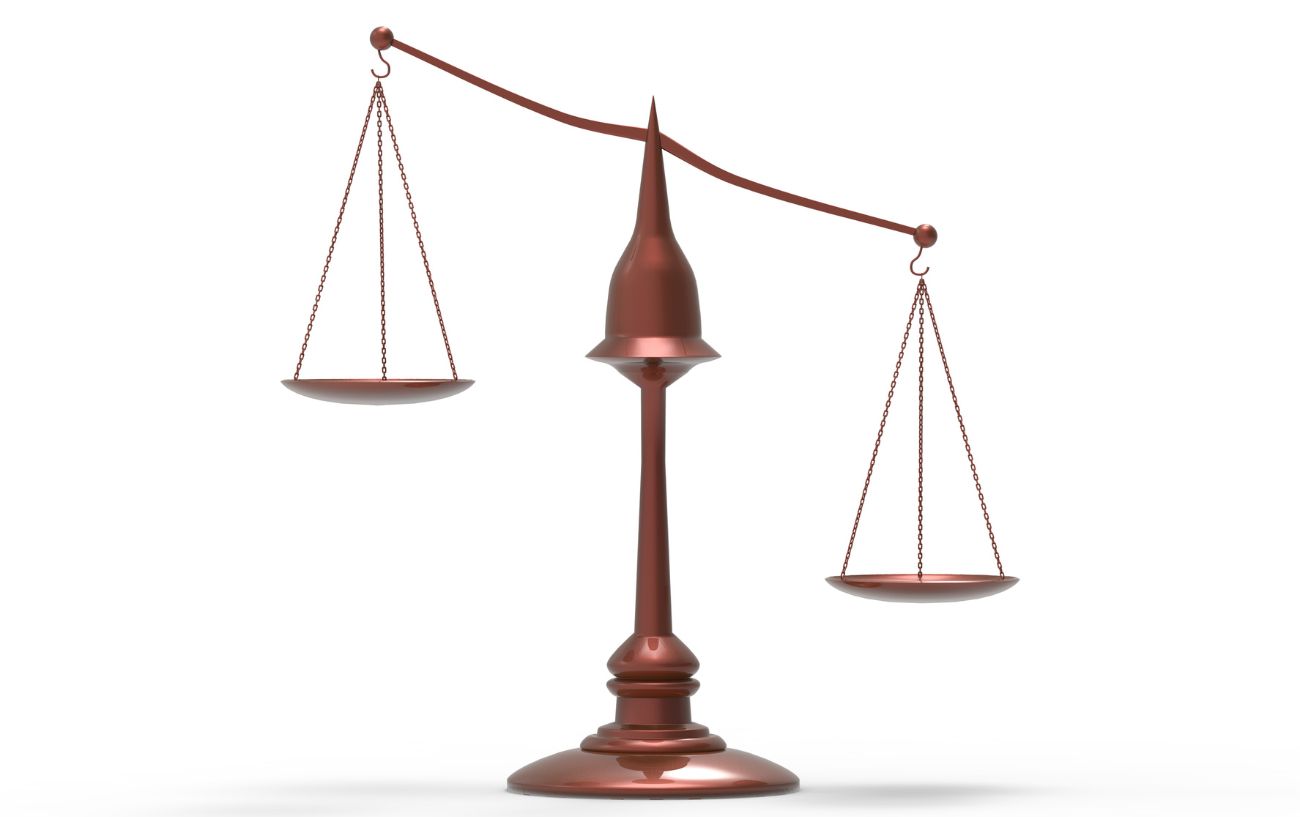 A set of bronze scales with a white background behind it.