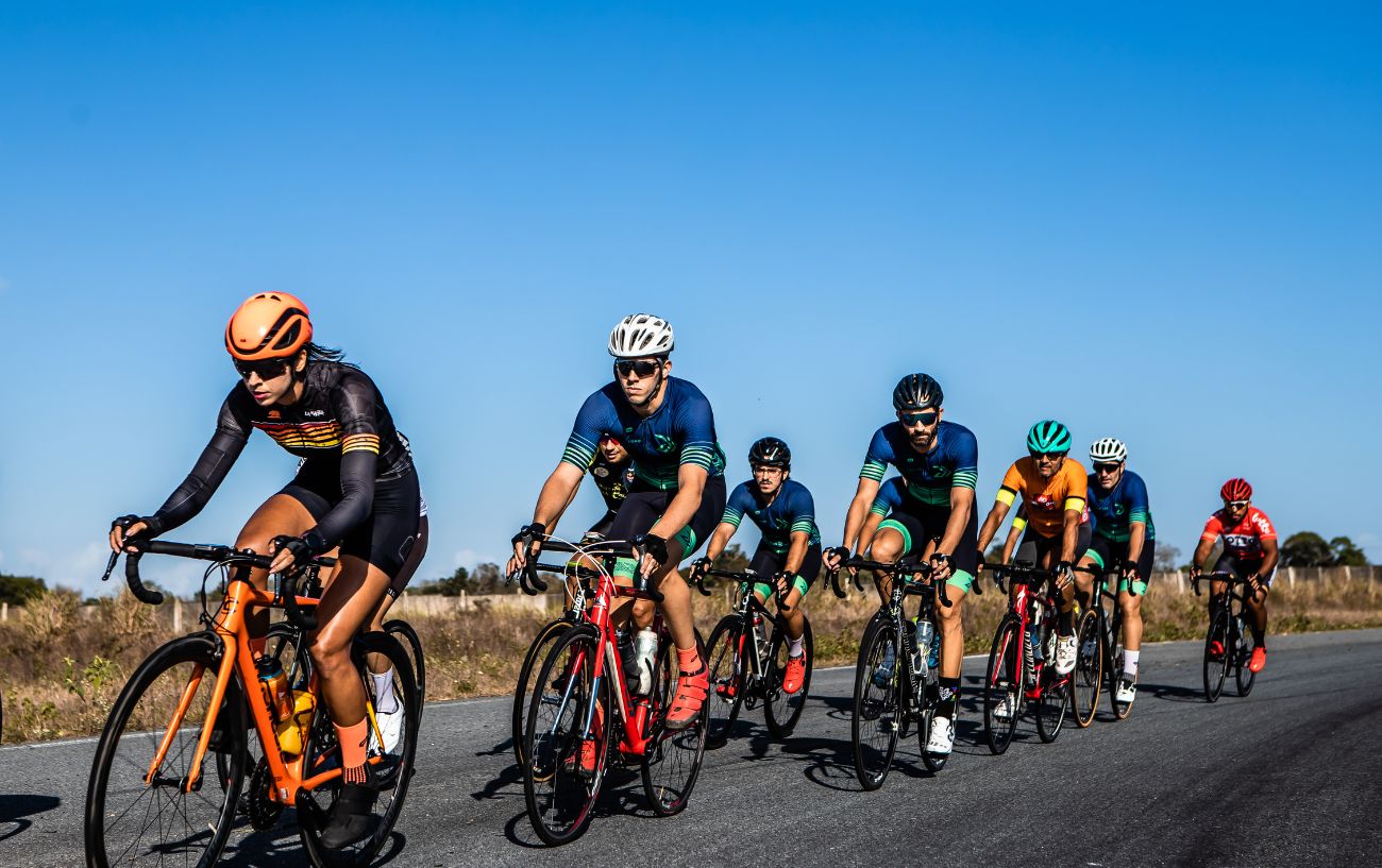 A group of road cyclists comparing a variety of bike brands on a tarmac racetrack, including Trek vs Giant.