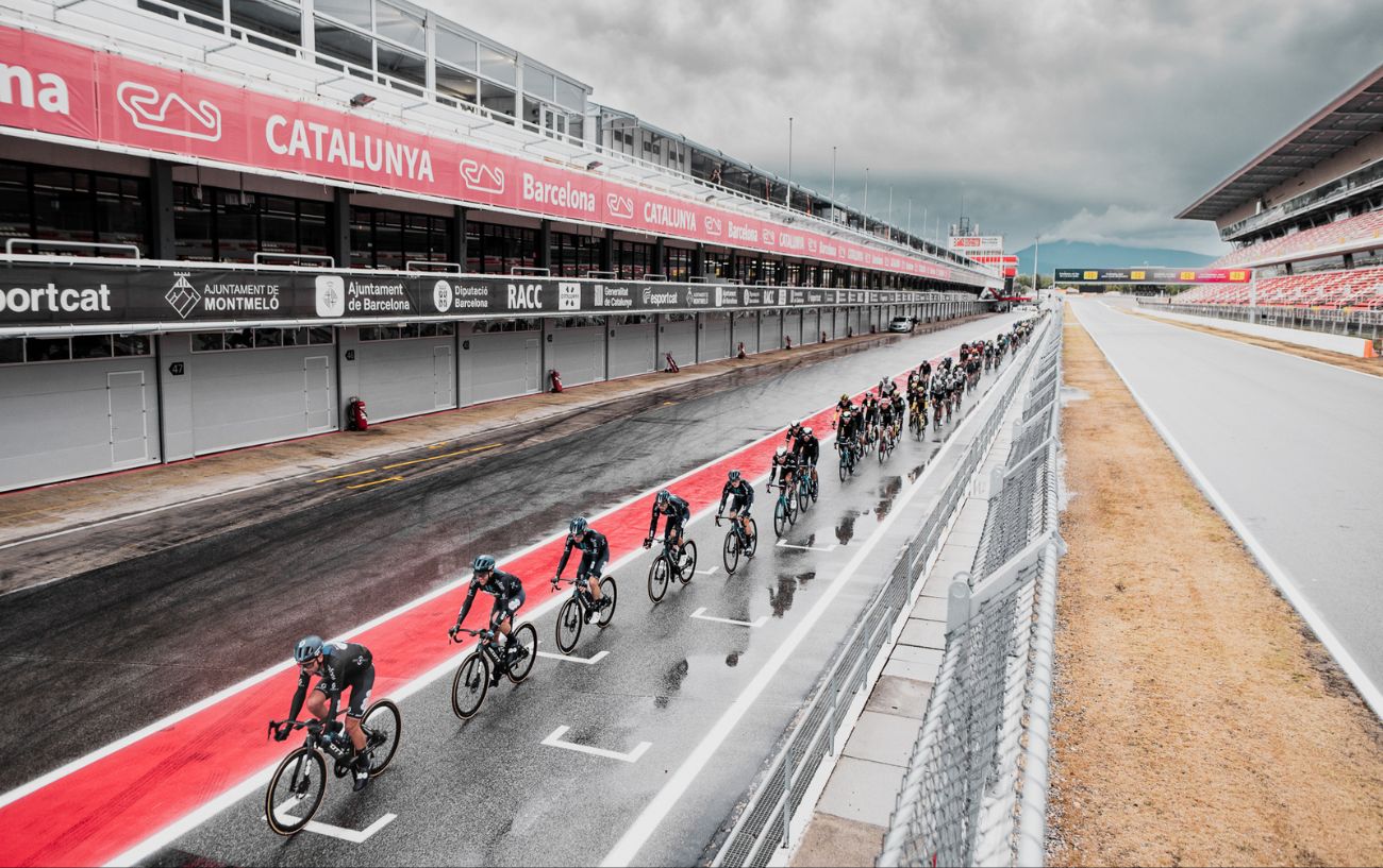 The peloton race through the pit lane at the Circuit de Catalunya on Stage 2 of the 2023 Vuelta.
