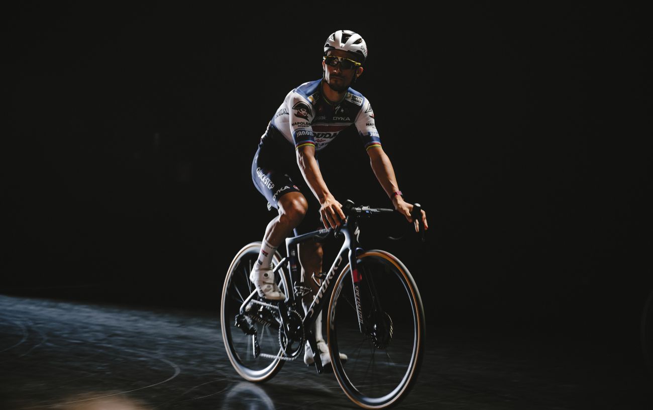 Julian Alaphilippe rides an S-Works road bike in a black studio.