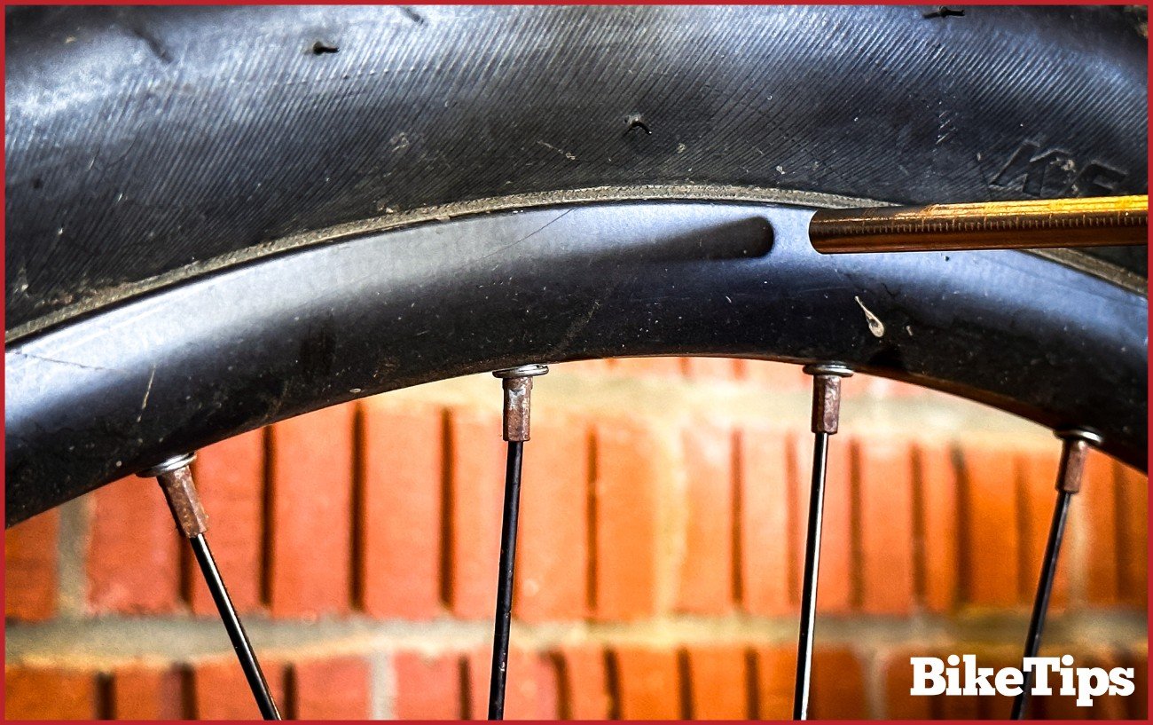 The rod of the derailleur alignment tool on the wheels rim.