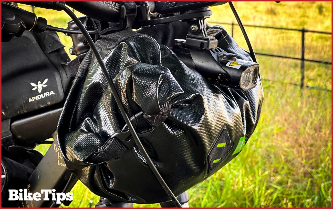 A mountain bike with a bikepacking front roll bag.