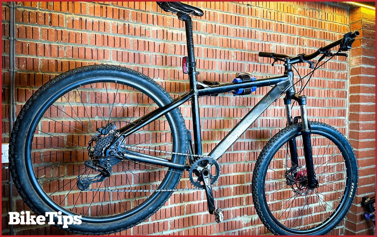 A mountain bike hanging on a wall stand.
