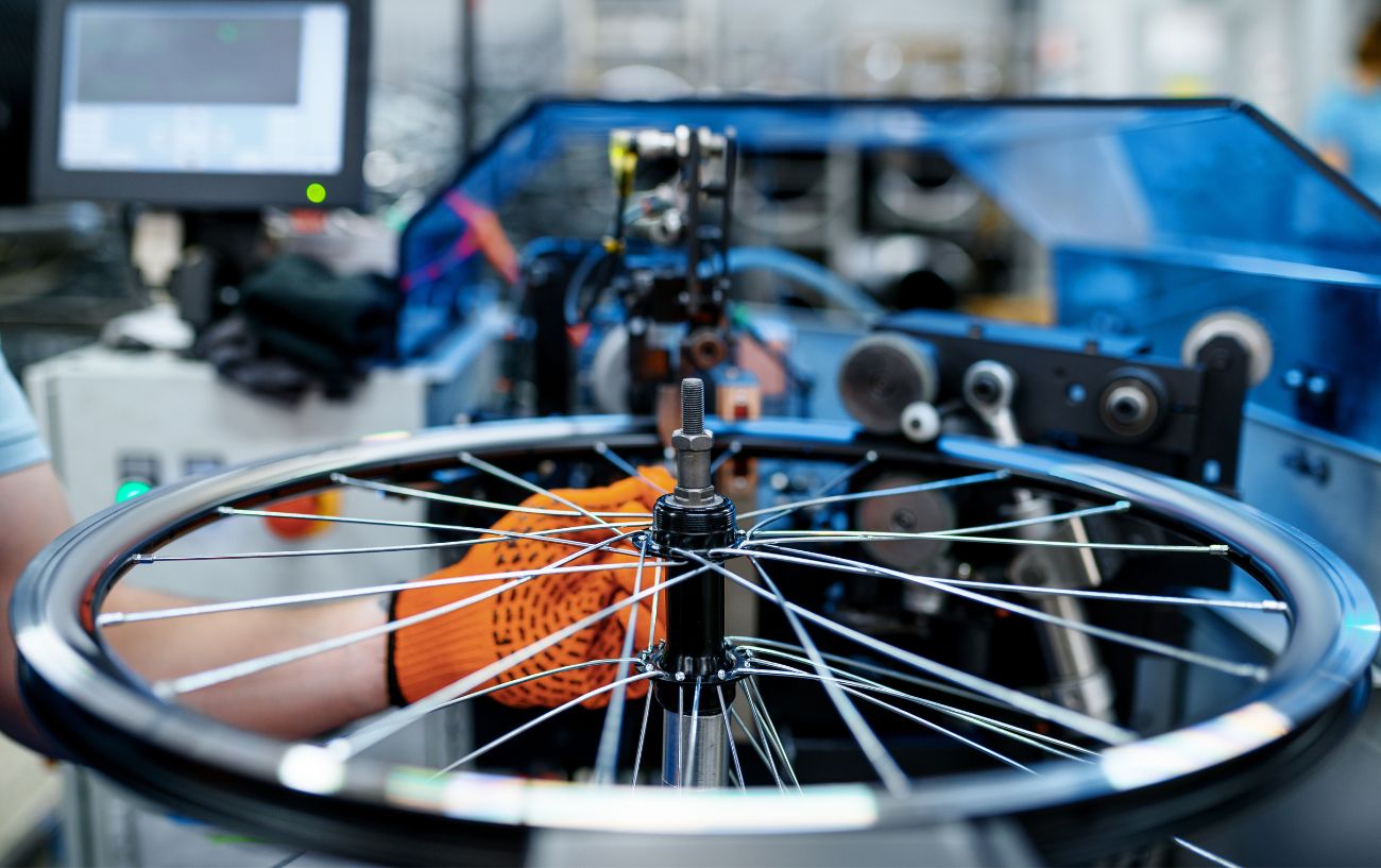 A road bike wheel is calibrated by a machine during manufacture.