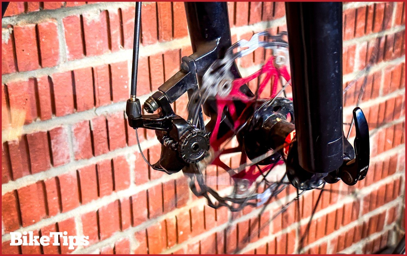 A spinning disc brake rotor on a bike in a stand.
