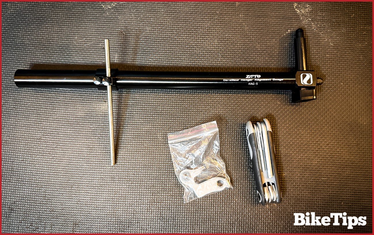 A derailleur alignment tool, Allen Keys, and a spare bike derailleur hanger. 