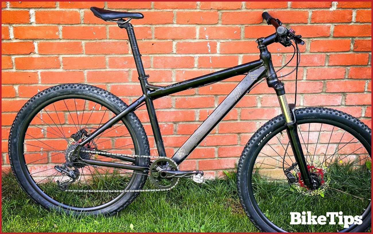 A mountain bike against a brick wall.