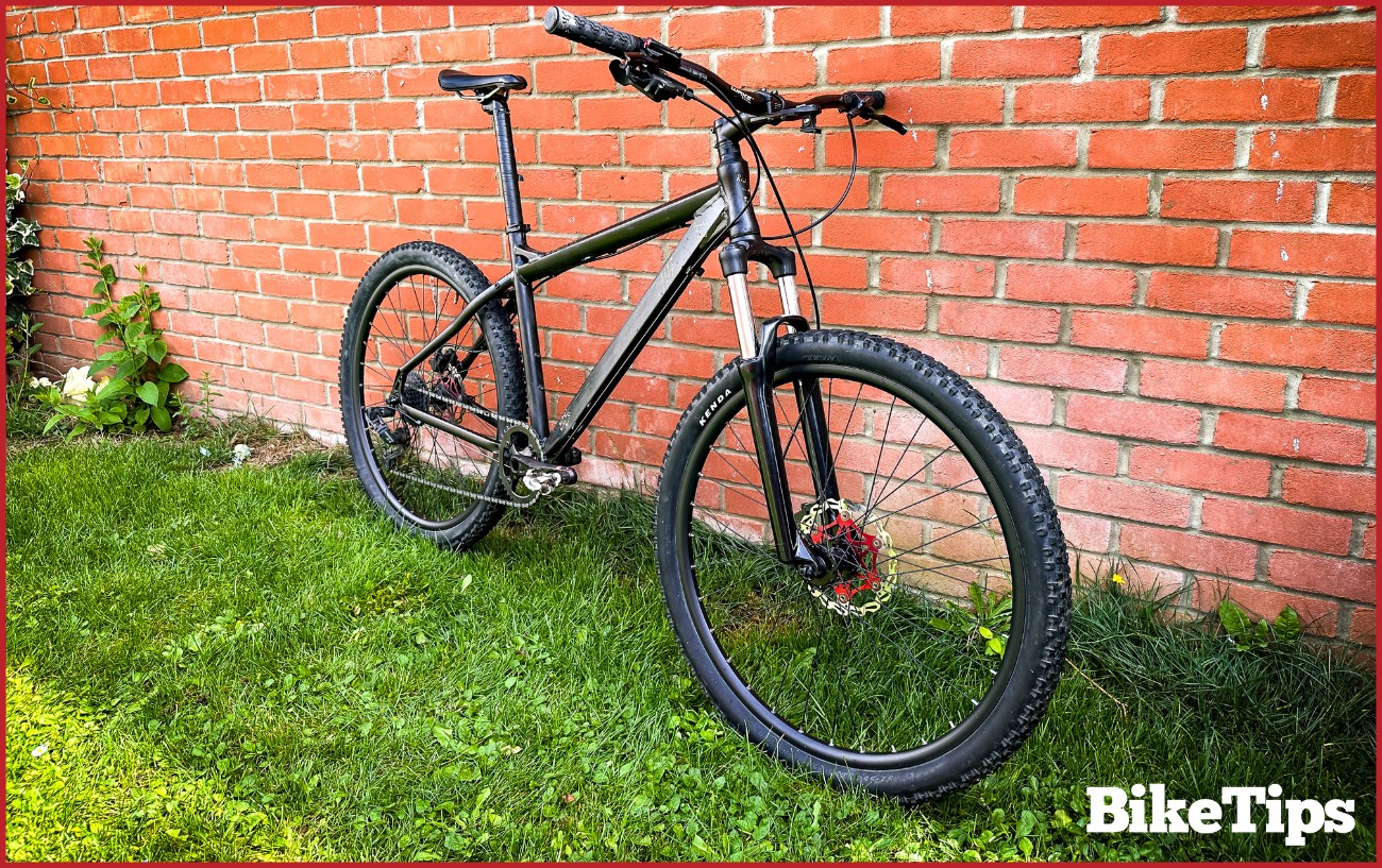 A mountain bike against a brick wall.
