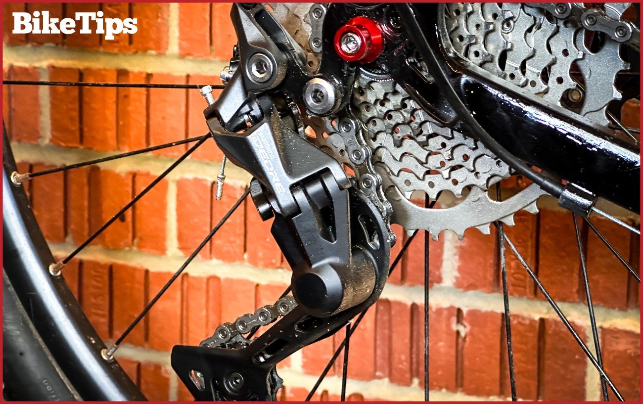 A close up of a bike's rear derailleur. Shimano Deore.