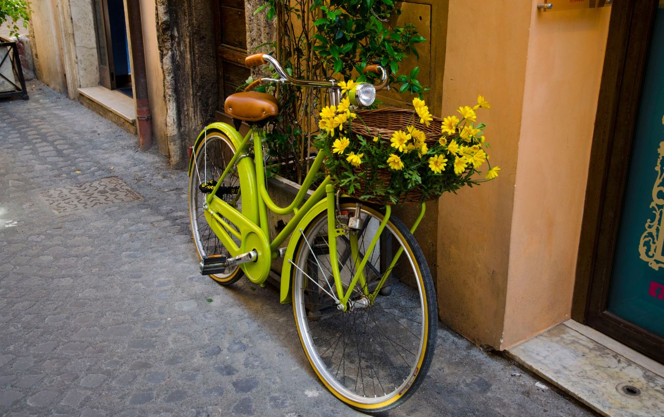 A lime green cruiser bike with yellow flowers in a basket.