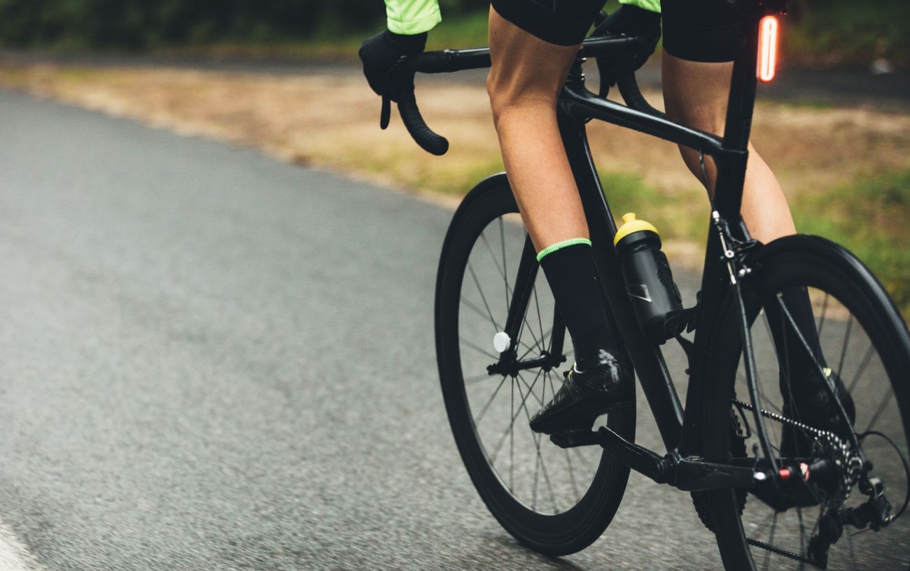 A black road bike on a wet tarmac road.