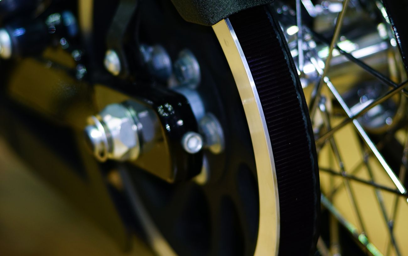 A close up of a belt drive on a black bicycle.