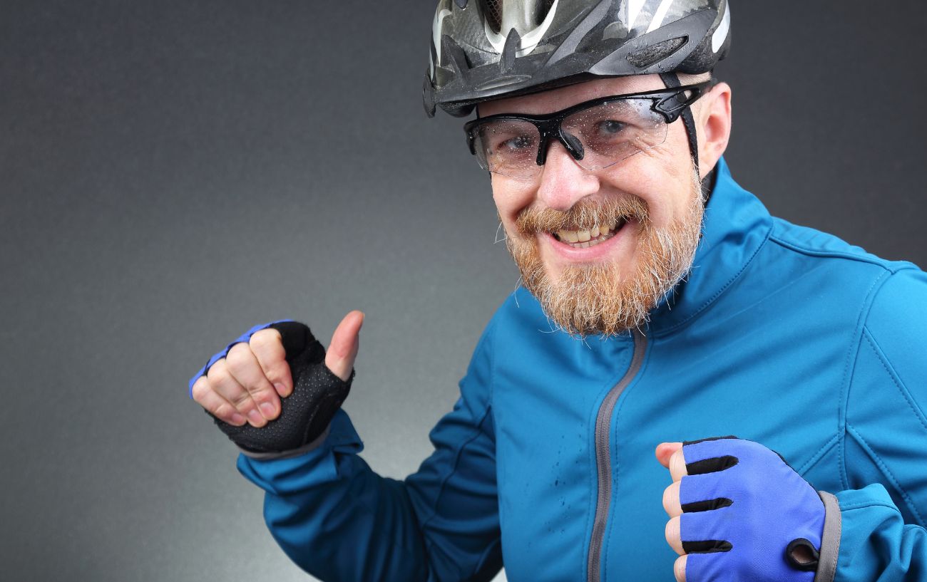 A cyclist in a blue jacket and wearing a helmet tells a joke about cycling.