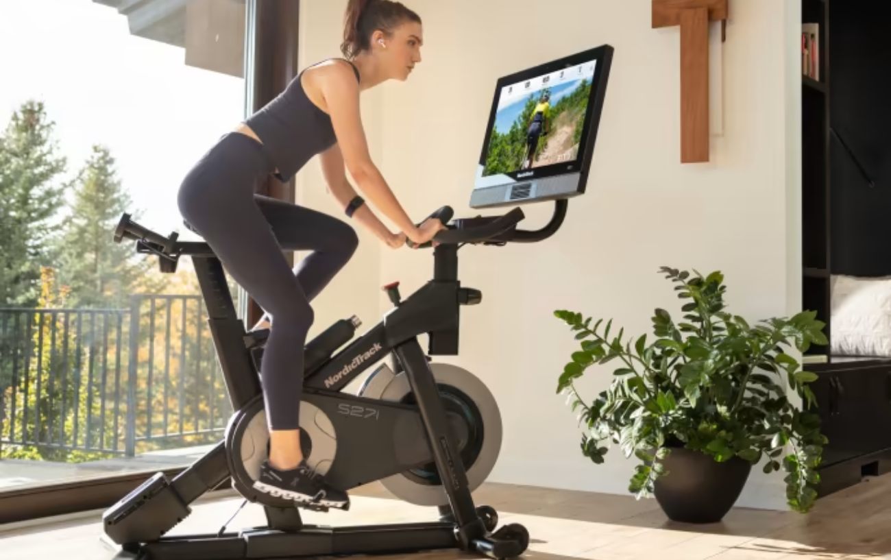 A woman cycles on an indoor nordictrack bike.