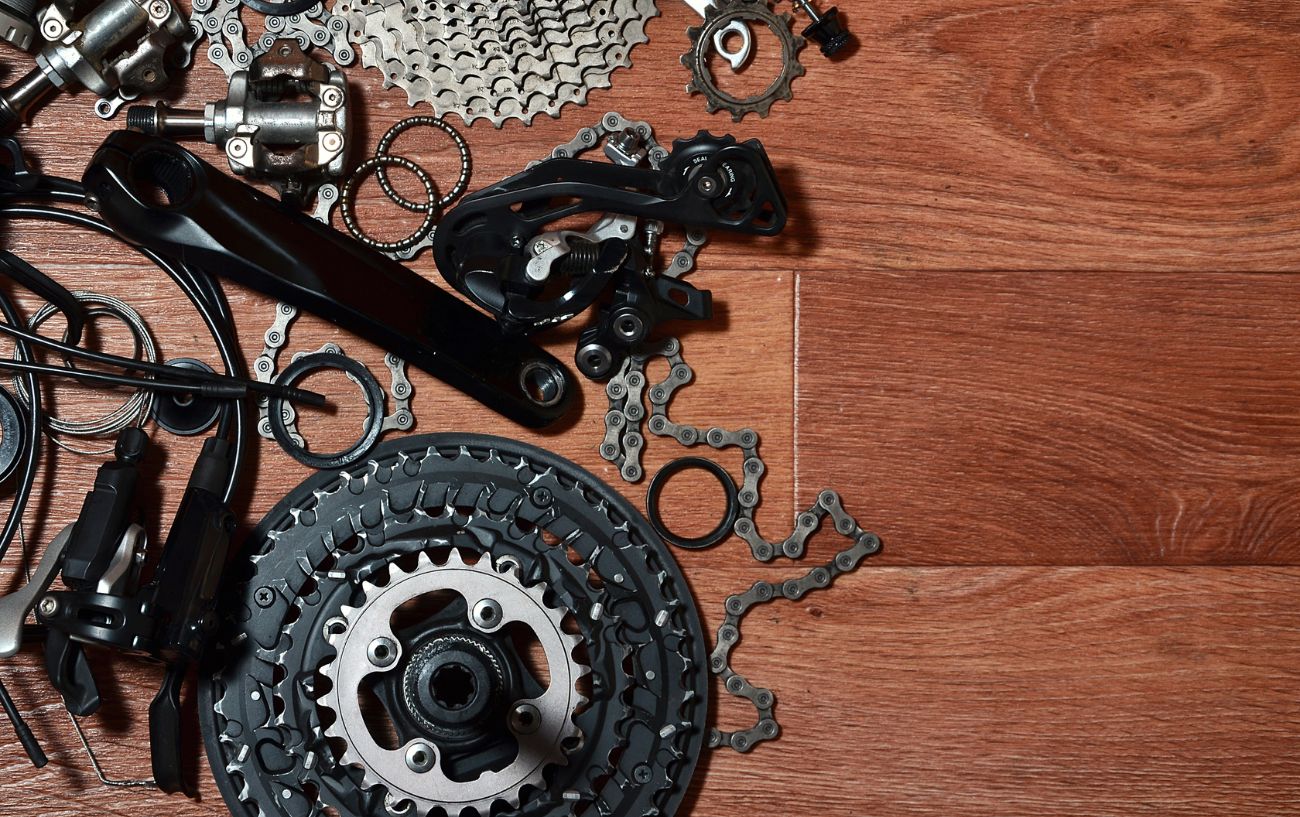 A disassembled mountain bike groupset lies on a wooden floor.