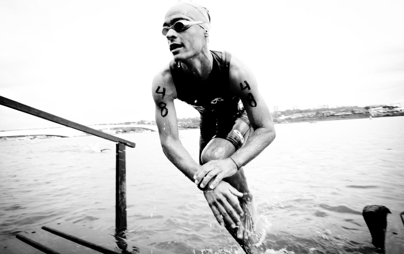 A triathlete emerges from the water during an Olympic triathlon distance.