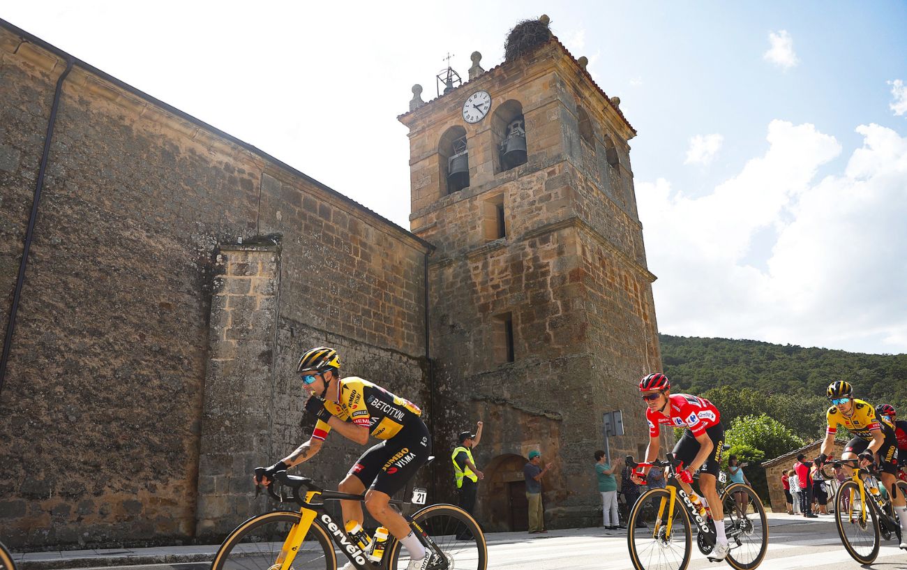 Sepp Kuss and his Jumbo-Visma teammates ride past a castle wall on Stage 11 of the 2023 Vuelta a Espana.