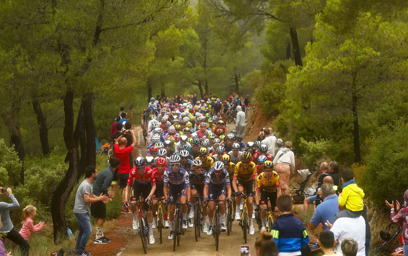 The peloton climbs a narrow, muddy climb on Stage 9 of the 2023 Vuelta a Espana.