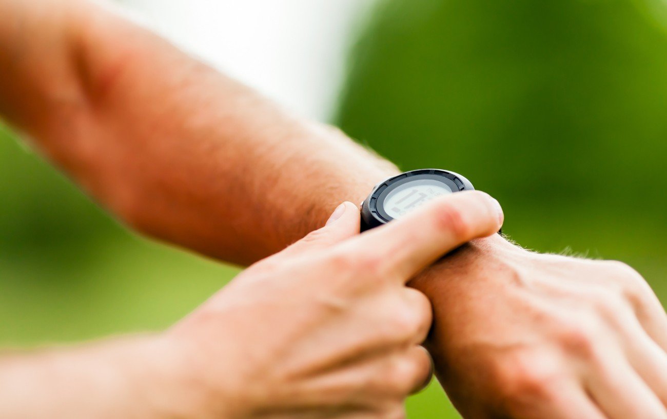 A man holds his arm up to record a sporting activity on his watch.