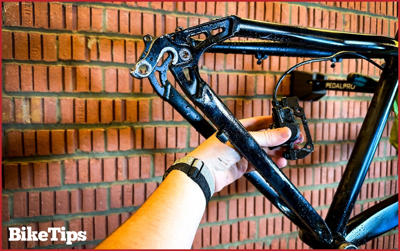 Removing a brake caliper from a mountain bike.
