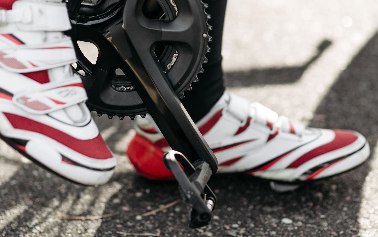 A cyclist pauses having unclipped from their pedals.