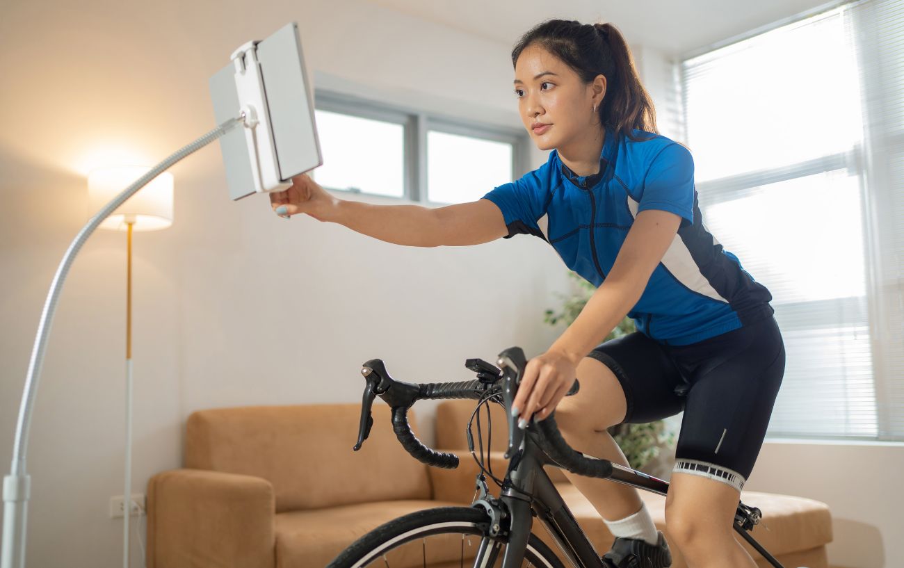 A cyclist in a blue jersey rides an indoor bike having resolved saddle sore issues.