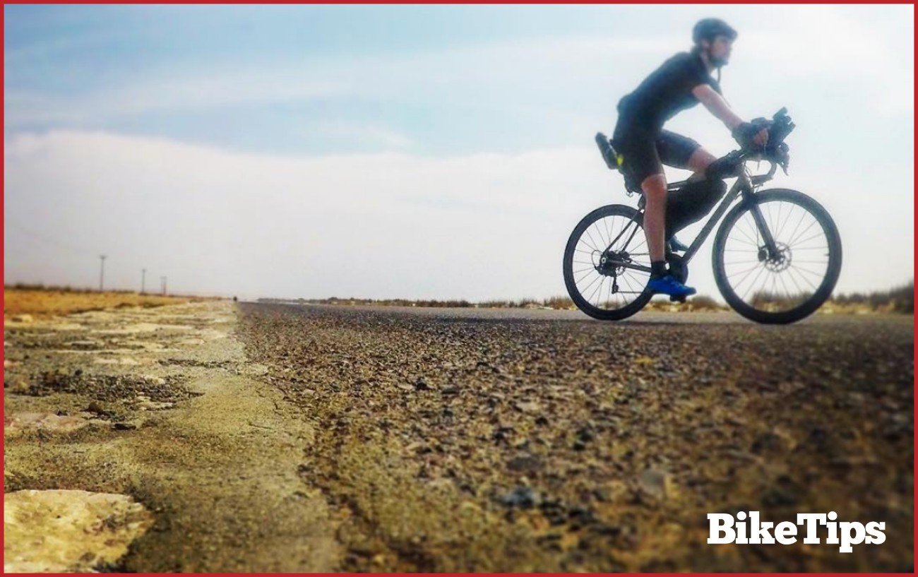 Photo of me bikepacking on a desert road in Oman.