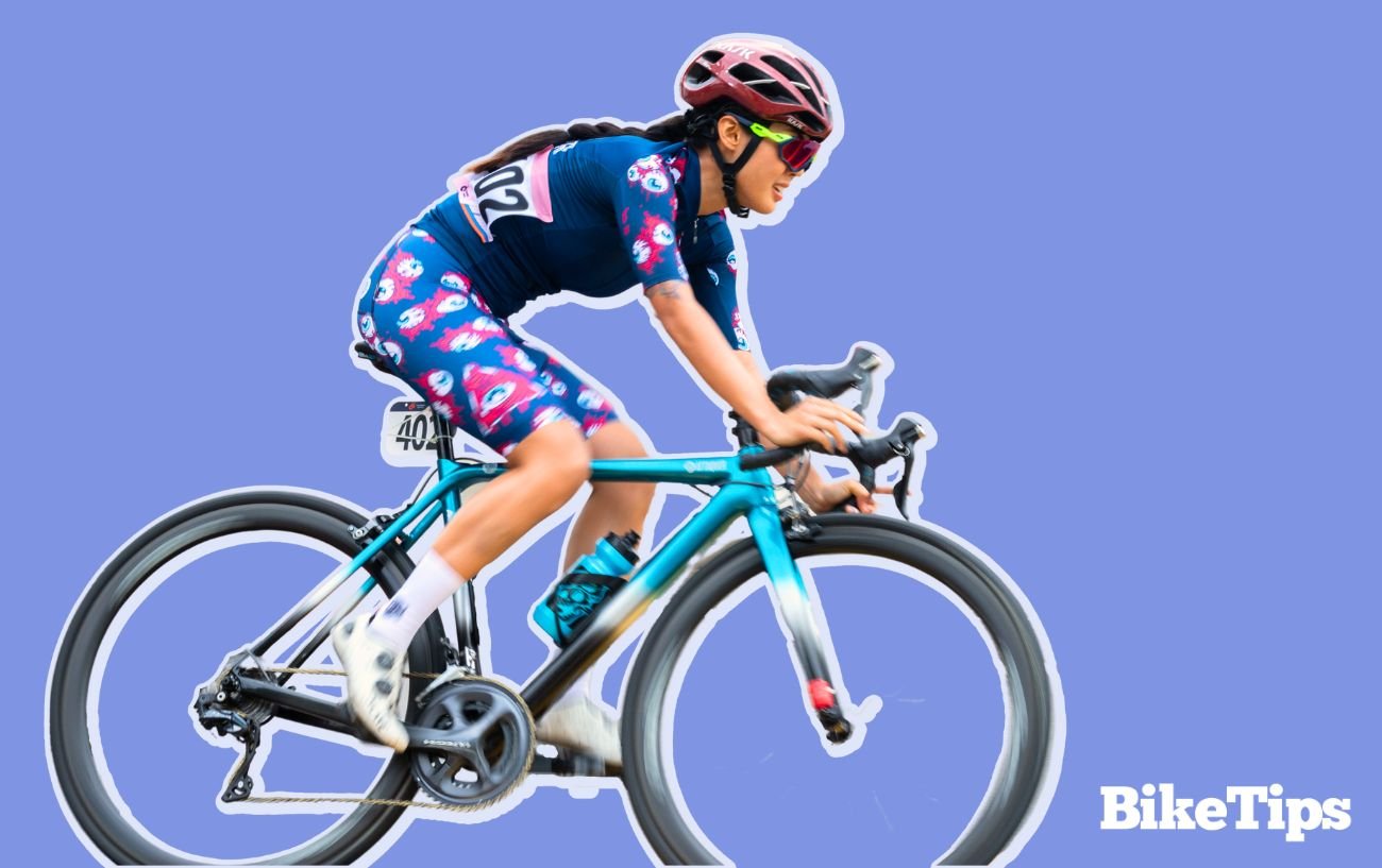 Graphic showing a cyclist racing on a turquoise road bike on a purple background.