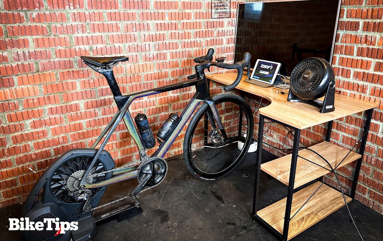 An indoor cycling setup in a brick garage, being used for training to improve climbing performance.
