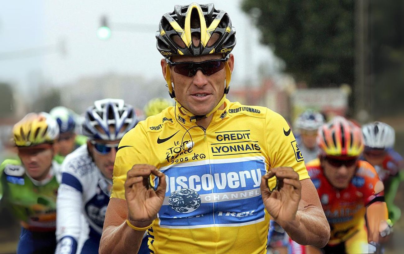 Lance Armstrong wearing the yellow jersey at the 2005 Tour de France gestures to the camera.