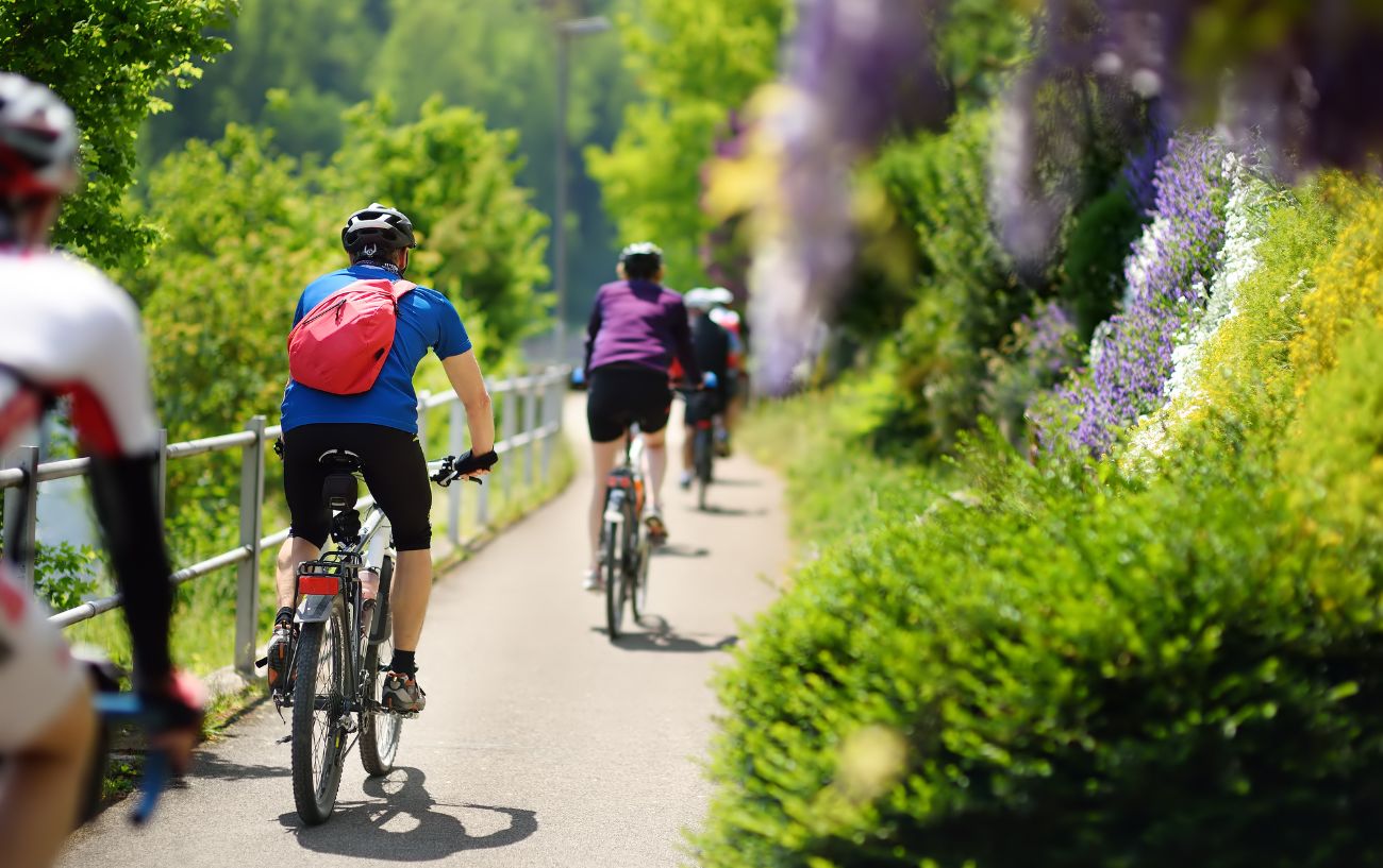 A group of cyclists ride out of the city into the countryside.